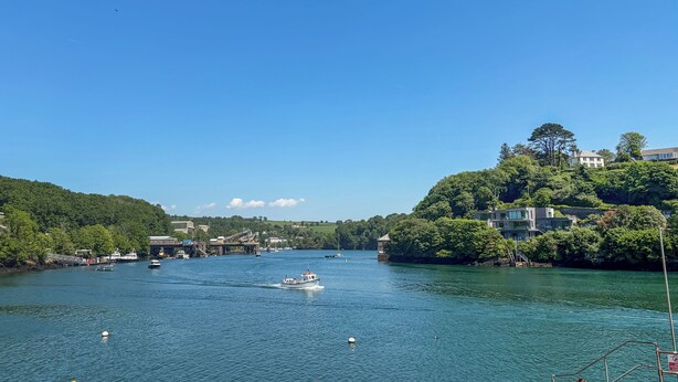Un fiume con barche, un ponte e edifici sulle rive.