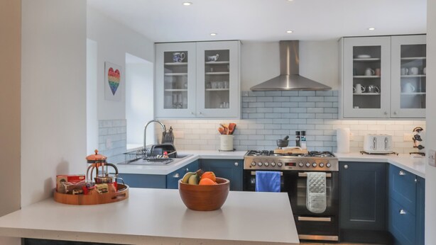 Una cucina moderna con un'isola centrale, un fornello e pensili.