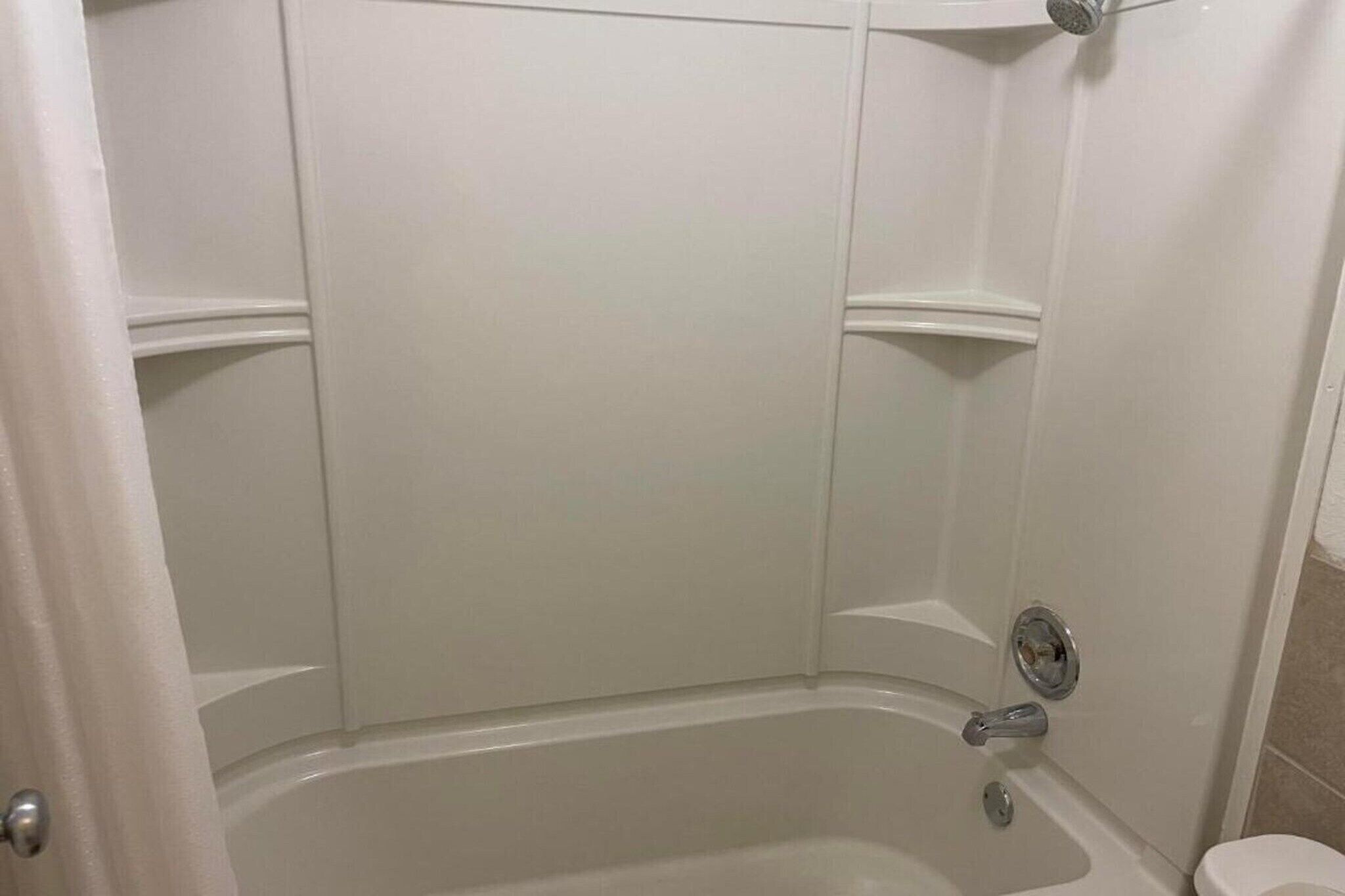 Ein Badezimmer mit Badewanne, Dusche und Toilette.