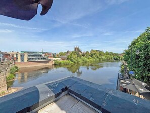 A riverside view with buildings, a bridge, and a church in the distance. - Period-style studio apartment in Hereford with a gentle, vintage charm. (Hereford)
