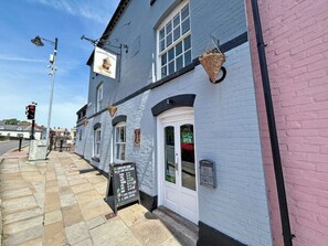 A traditional pub with a signboard, a chalkboard menu, and a hanging basket. - Period-style studio apartment in Hereford with a gentle, vintage charm. (Hereford)