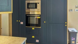 Eine Küche mit Mikrowelle, Backofen und Schränken.
