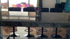 A modern interior with a marble bar, seating area with chairs and tables, and a view through large windows. - House on the shores of Lake Fainu, with a magnificent view, peaceful and relaxing. (Tahaa)