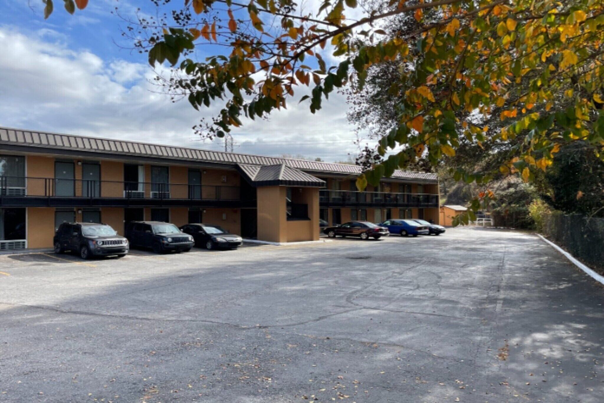 A building with a parking lot and several parked cars.
