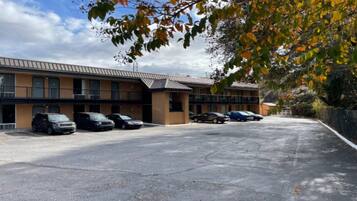 A building with a parking lot and several parked cars.