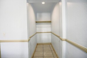 A narrow hallway with white walls and a tiled floor. - 2 Queen Bed|Smk|Day & Night Inn (Hesperia CA)