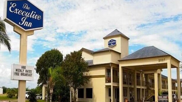 The Executive Inn with a sign indicating HBO weekly rates free breakfast.