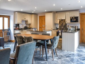 Een moderne keuken met een centraal eiland, een eettafel en stoelen.