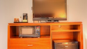 Una kitchenette equipada con microondas, cafetera y un refrigerador pequeño.