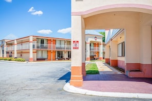 Un hôtel avec un panneau indiquant qu’il n’y a pas de parking, une allée couverte et une entrée.