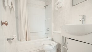 Een badkamer met een bad, toilet en wastafel.