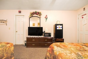 Une chambre d’hôtel avec un lit, une commode, une télévision, un four à micro-ondes et une enseigne « Sunflower Motel ».
