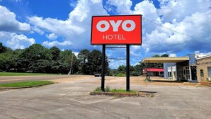 A hotel sign with 'OYO HOTEL' written on it, a gas station, and a road in the background.