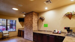 A kitchen with a brick column, a sink, a coffee machine, and a window with a view of the street. - Houston| 2 Full Bed | non-smoking (Houston)