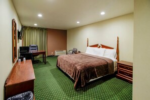 Ein Hotelzimmer mit Bett, Schreibtisch, Stuhl und einem an der Wand befestigten Fernseher.