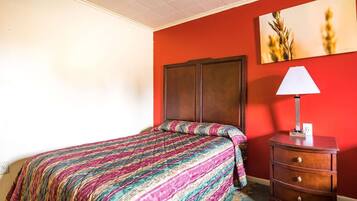 Una habitación con una cama, un tocador y un cuadro en la pared.