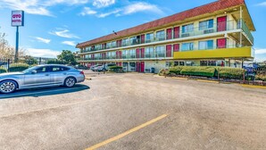 Un motel à plusieurs étages, avec un toit rouge, des balcons et une enseigne indiquant qu’il s’agit d’un hôtel OVO.
