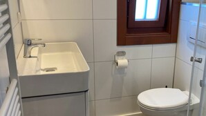 A bathroom with a white sink, toilet, and a small window above the toilet. - Holiday Home in Susteren With Terrace (Susteren)