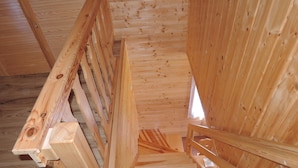 Eine Holztreppe mit Handlauf, die zu einer höheren Etage führt.