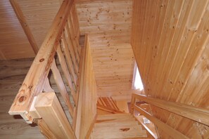 Eine Holztreppe mit Handlauf, die zu einer höheren Etage führt.
