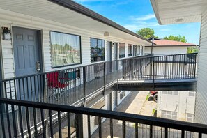 A row of mobile homes with balconies and a gated driveway. - Family room with 2 Double Beds (Albany GA)