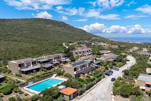 Un quartiere residenziale con case, una piscina e una strada.