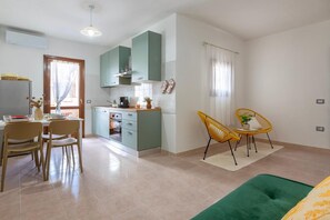 Eine moderne Küche mit Essbereich, einer Couch und einem kleinen Tisch mit Stühlen.