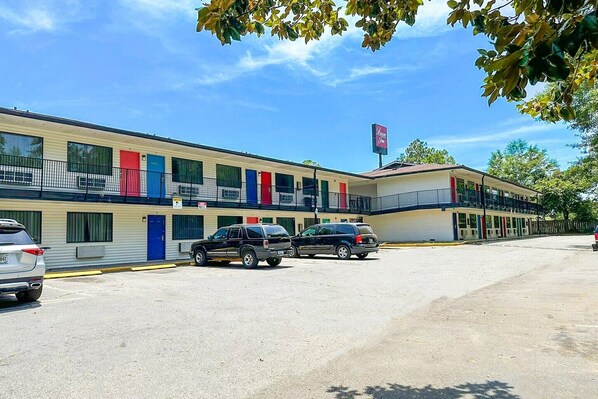 Ein Motel mit mehreren Zimmern, einem Parkplatz und einem Schild, das ein Restaurant anzeigt.
