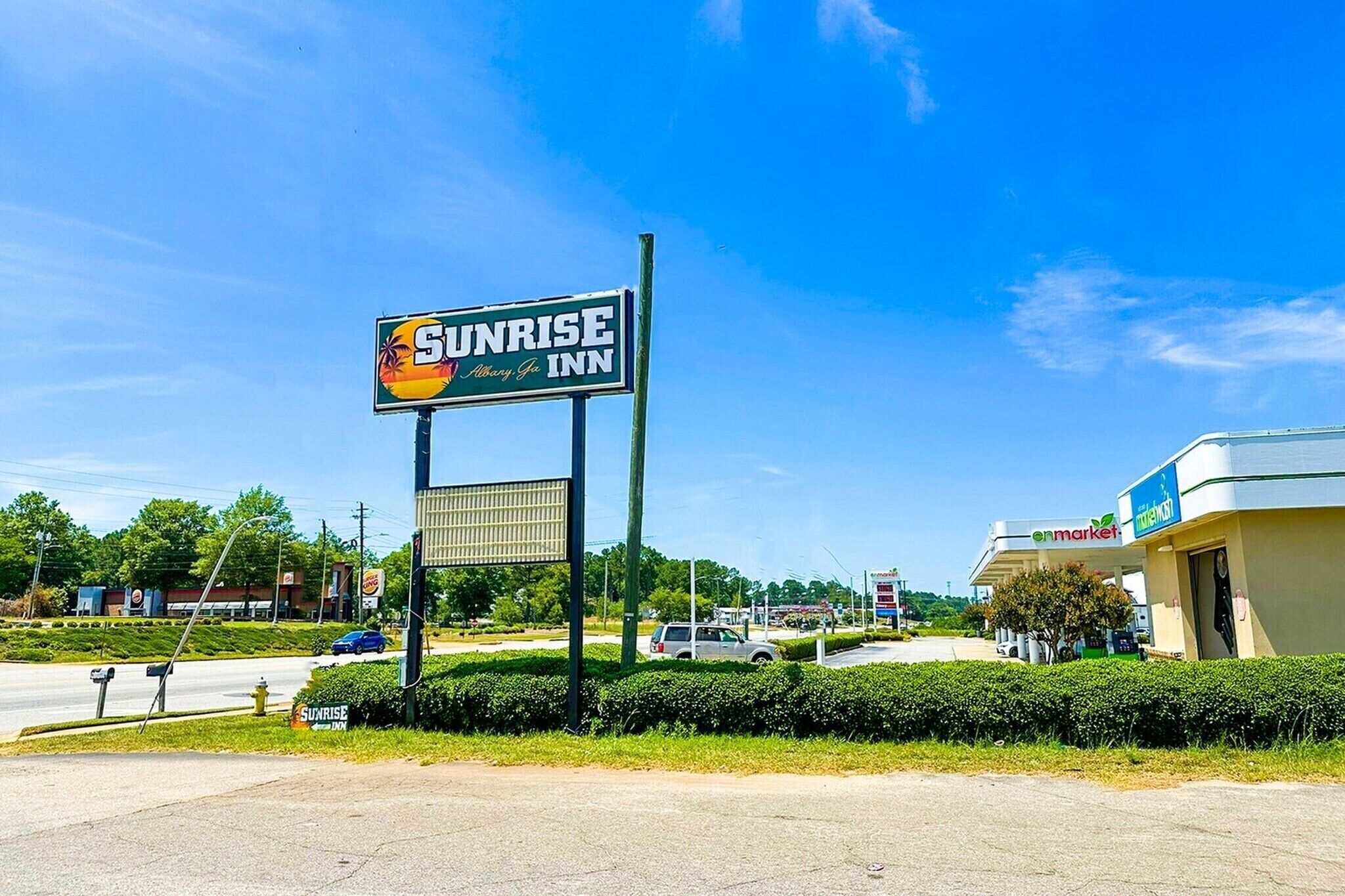 Señal de Sunrise Inn con una vista clara del nombre y logotipo del hotel.