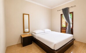 A bedroom with a bed, a nightstand, a mirror, and a window with curtains. - New Dgyp Resort Ciater (Ciater)
