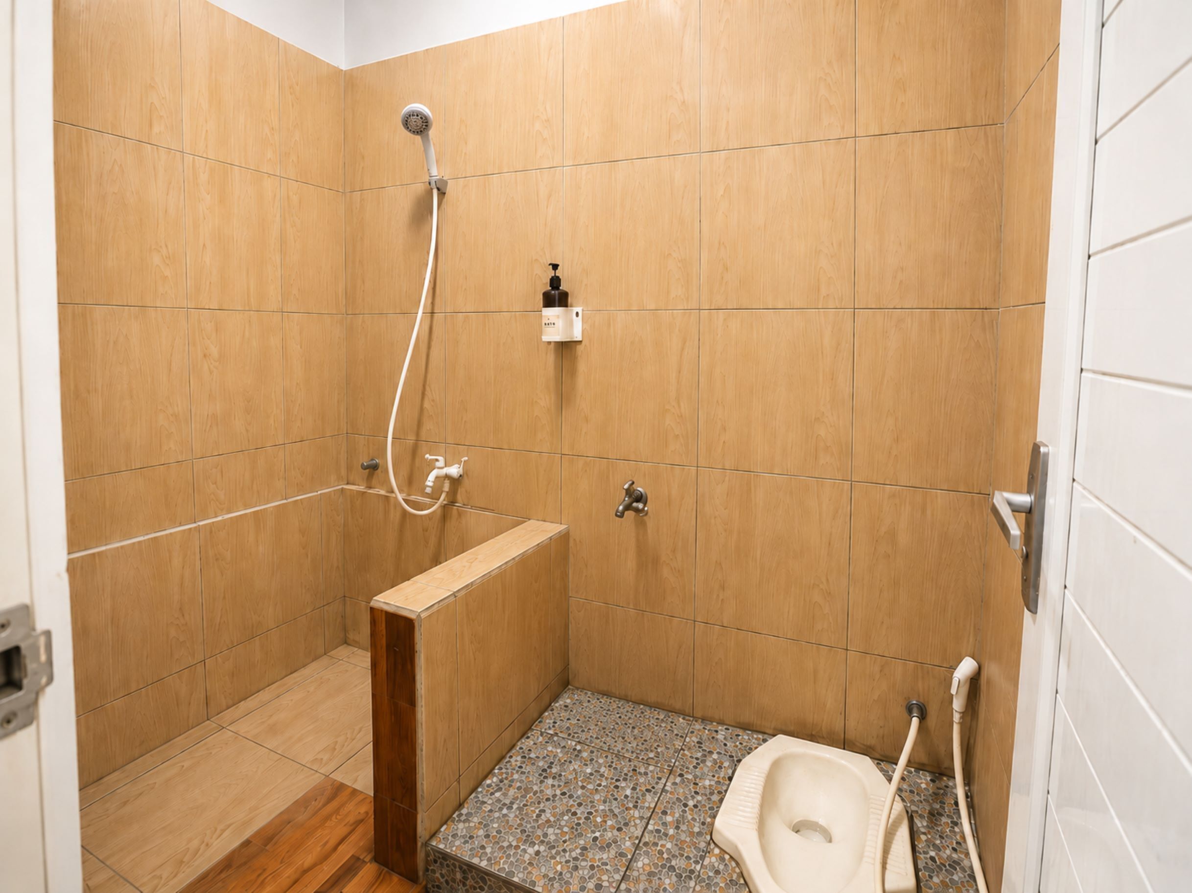 Un baño pequeño y funcional con ducha, inodoro y lavamanos.