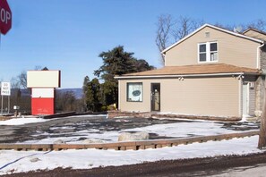A building with a 'DO NOT PASS' sign, a 'OPEN' sign, and a stop sign.