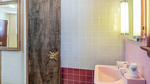 A bathroom with a wooden door, a sink, and a mirror. - 2 Queen Bed|Non-Smoking (Wilkes-Barre PA)