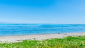 A beach with clear blue water and a sandy shore.