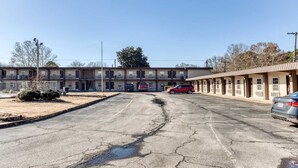 A motel with a parking lot, multiple rooms, and a small garden area. - King Bed|Non-Smoking (Bald Knob AR)