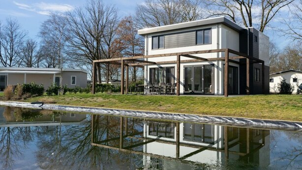 A modern two-story house with a covered patio and a pond in front. - Pavilion L'etage Sauna 10 (Susteren)