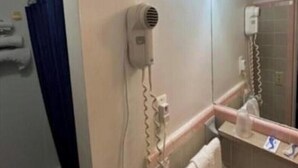 A bathroom with a hairdryer mounted on the wall, a sink, and a mirror. - 2 Full Bed | non smoking (Bay City, MI)