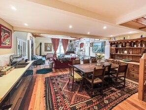 A spacious living area with a dining table, sofas, and a kitchen area with a sink and counter. - 2 bedroom accommodation in Colne Engaine (Colne Engaine)