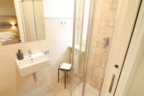 Ein Badezimmer mit Waschbecken, Spiegel und Dusche.