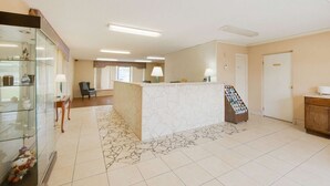A reception area with a marble counter, a glass display case, a reception desk, and a patterned rug.