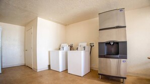 A laundry room with two front-loading washers, a stainless steel refrigerator, and a water dispenser.