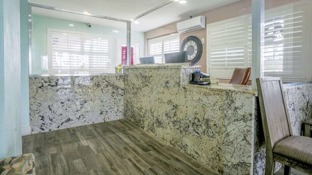 A reception area with a marble counter, a laptop, and a clock on the wall. - 2 Full Beds Non-Smoking (Buttonwillow, CA)