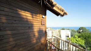 A wooden building with a sign reading 'Zen free suite' and a view of the sea.