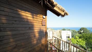 Un bâtiment en bois avec une enseigne indiquant « Suite zen, accès libre » et une vue sur la mer.