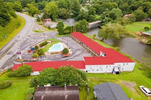 Ein großes Gebäude mit rotem Dach, Swimmingpool und Parkplatz.