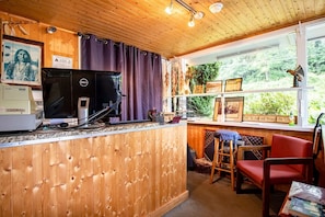 Um interior de madeira com uma mesa, computador e cadeiras.