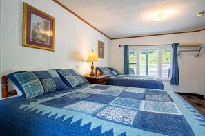 A bedroom with two beds, a dresser, a lamp, and a window with curtains. - 2 Bedroom Apartment with Kitchen (Bryson city)