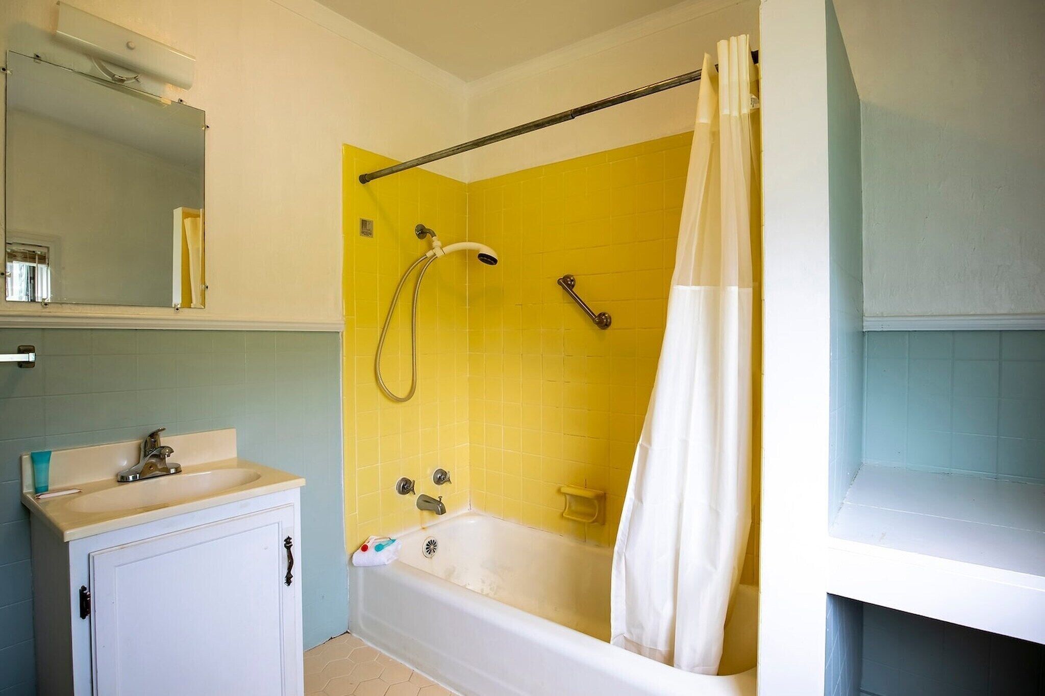 Une salle de bain avec une baignoire, une douche, un lavabo et un miroir.