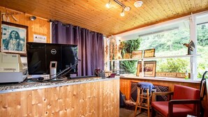 Un intérieur en bois avec un comptoir de cuisine, un ordinateur Dell et une fenêtre donnant sur un paysage verdoyant.