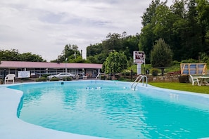 A swimming pool with a lifeguard sign, a covered area, and a sign for a country inn.